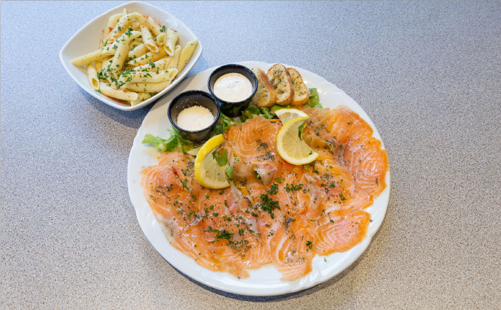 Présentation d'un plat à base de saumon et pâtes servis au restaurant les frangins à Saint-Omer